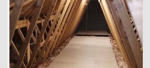 A narrow boarded strip between roof slopes, insulation visible along both edges